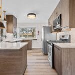 Kitchen with dark wood cabinets and stainless steel appliances in an Affordable Living Company home