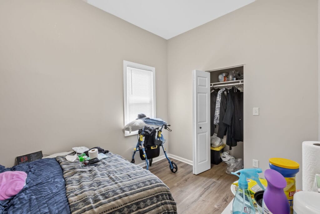 Furnished bedroom with a bed and closet space in an Affordable Living Company home