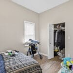 Furnished bedroom with a bed and closet space in an Affordable Living Company home