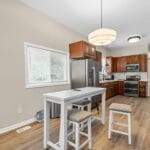 Kitchen with island seating and wood cabinetry in an Affordable Living Company home