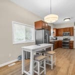 Open kitchen with island and wood cabinetry in an Affordable Living Company home