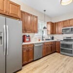 Kitchen with stainless steel appliances and wood cabinets in an Affordable Living Company home