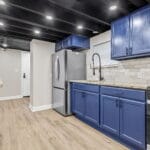 Modern kitchen with blue cabinets in an Affordable Living Company shared housing home