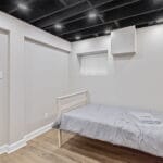 Furnished bedroom near a shared hallway in an Affordable Living Company home