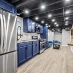 Modern kitchen with blue cabinetry and stainless appliances in an Affordable Living Company home