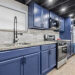 Kitchen with blue cabinetry and granite countertops in an Affordable Living Company home
