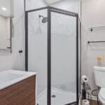 Bathroom with glass-enclosed shower in an Affordable Living Company home