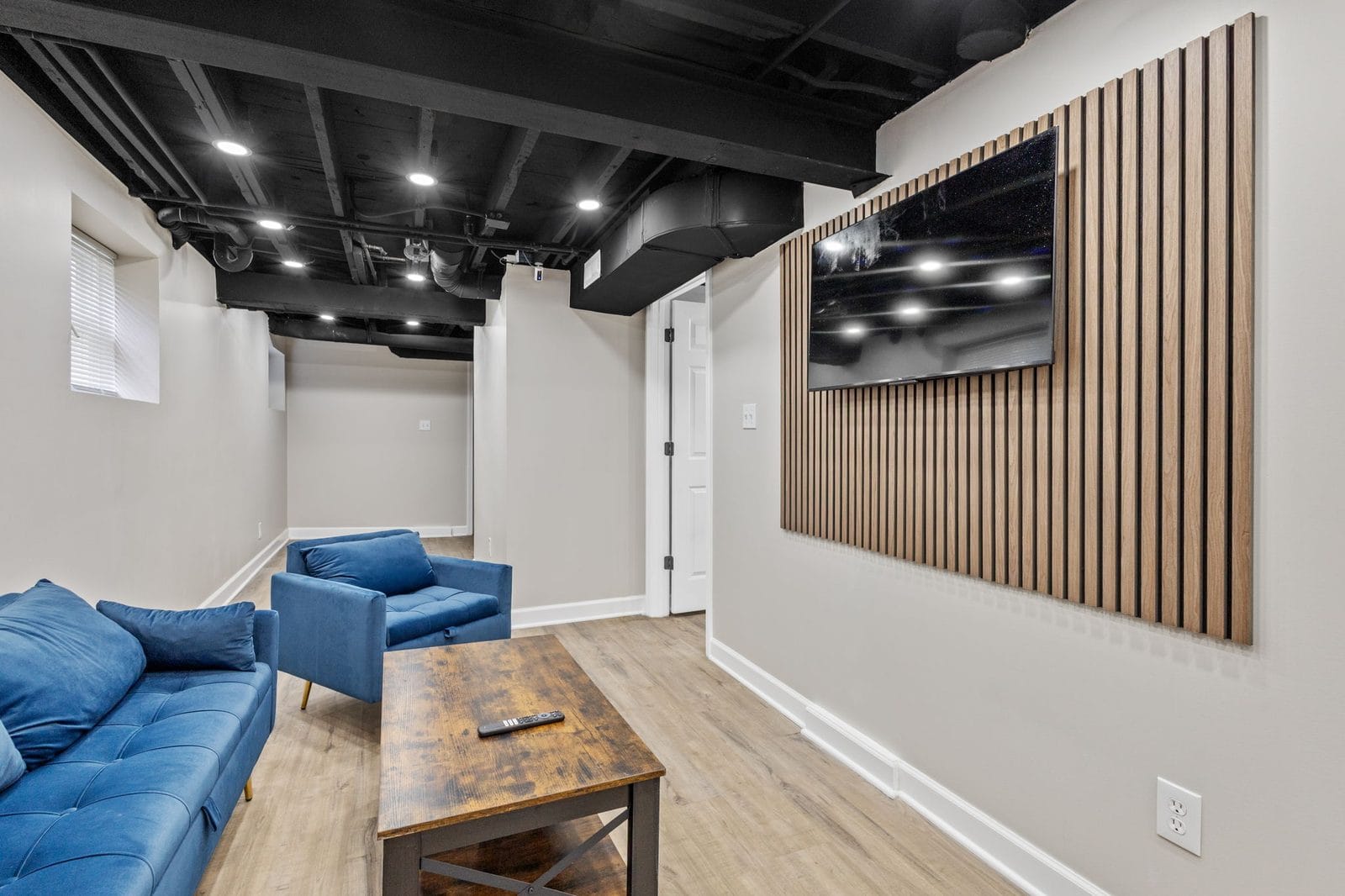 Lower level lounge with sofa, coffee table and wall mounted television in Hammond, Indiana