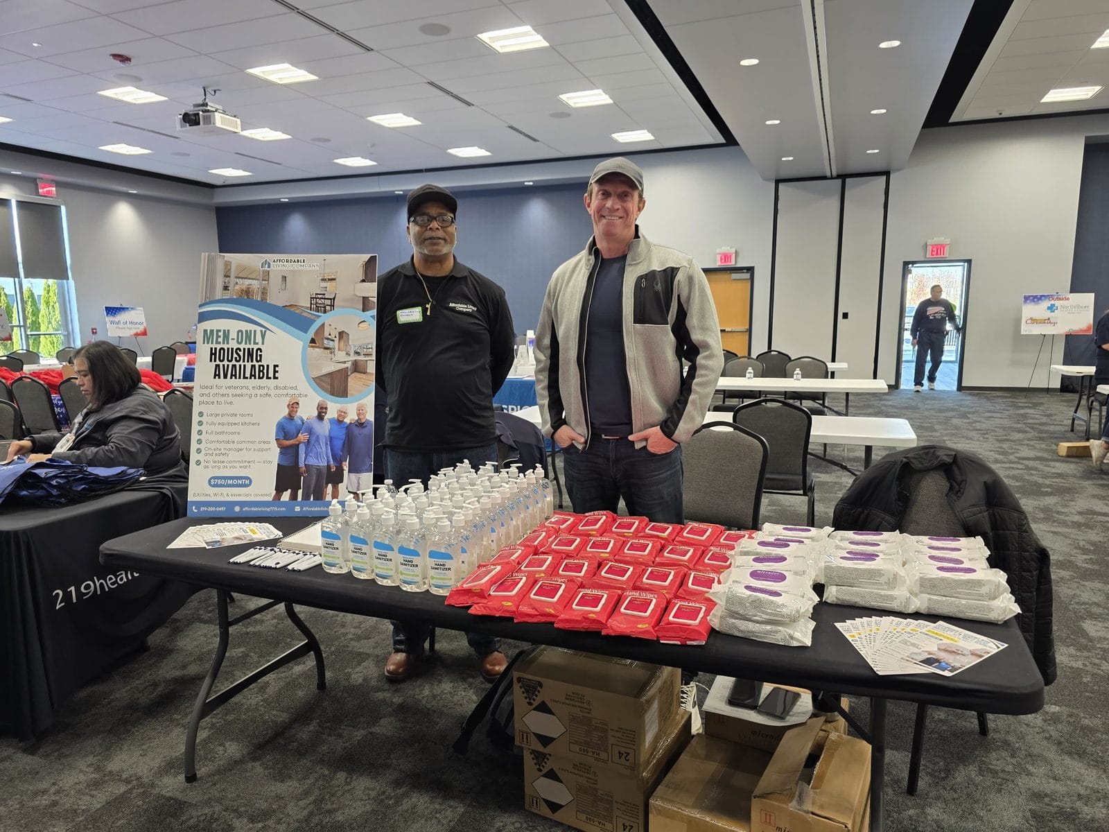 Hand sanitizer, bottled water, hygiene kits and housing flyers laid out on the Affordable Living Company table for veterans